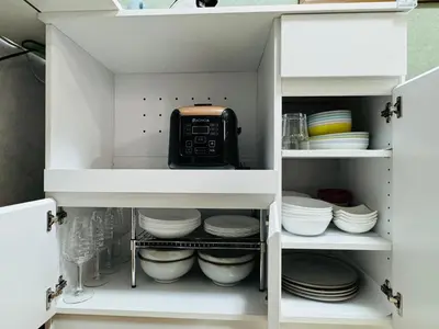 a kitchen cabinet filled with dishes and a microwave at Lucky you! TATEISHI in Tokyo
