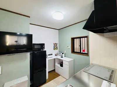 a kitchen with a black refrigerator and a microwave at Lucky you! TATEISHI in Tokyo