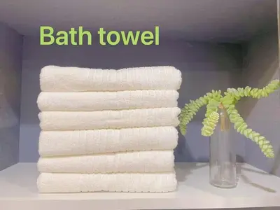 a stack of towels on a shelf next to a vase with a plant at \u5fc3\u306e\u5bbf in Tokyo