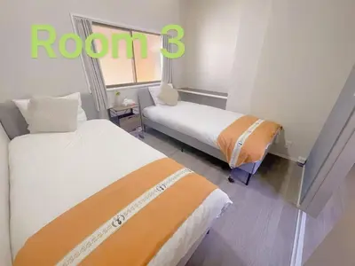 a room with two beds and a sign that reads room six at \u5fc3\u306e\u5bbf in Tokyo