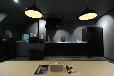a black kitchen with a table and two lights at ACOE Nakano-Sakaue Holiday Home 5 Minutes to Shinjuku in Tokyo