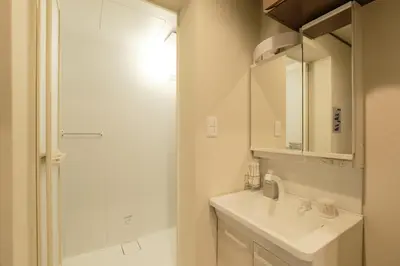 a white bathroom with a sink and a mirror at ACOE Nakano-Sakaue Holiday Home 5 Minutes to Shinjuku in Tokyo
