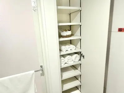 a bathroom closet with white towels on shelves at Latte Oshiage Comfort Stay, 10min walk to Tokyo Skytree in Tokyo