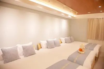 a bedroom with two beds with white pillows and a teddy bear sitting on at \u68ee\u4e0b\u5c0f\u5c4b in Tokyo
