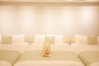 two beds with a teddy bear sitting between them at \u68ee\u4e0b\u5c0f\u5c4b in Tokyo