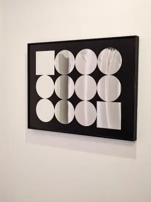 a black frame with white circles on a wall at \u30b3\u30fc\u30c8\u30cf\u30a6\u30b9\u4e09\u8336 in Tokyo