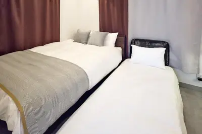 two beds sitting next to each other in a room at \u30b3\u30fc\u30c8\u30cf\u30a6\u30b9\u4e09\u8336 in Tokyo