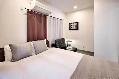 a bedroom with a white bed and a chair at \u30b3\u30fc\u30c8\u30cf\u30a6\u30b9\u4e09\u8336 in Tokyo