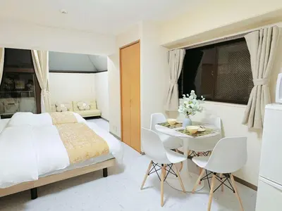 a bedroom with a bed and a table and chairs at F-Mansion210 in Tokyo