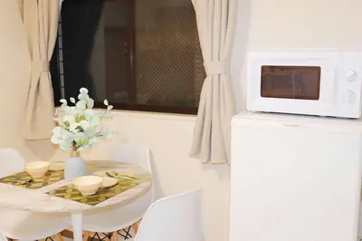 a small table with a microwave on top of a refrigerator at F-Mansion210 in Tokyo