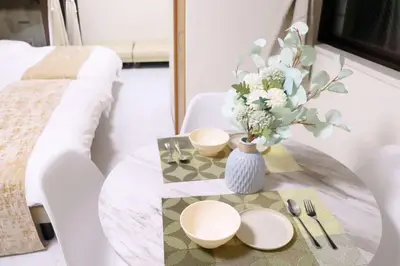 a table with plates and a vase with flowers on it at F-Mansion210 in Tokyo