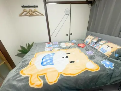 a bed with a teddy bear pattern on it at Takadanobaba relaxing CB in Tokyo