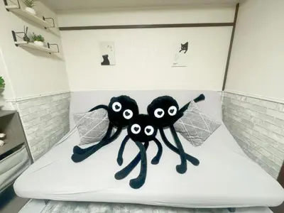 two black stuffed spiders sitting on a bed at Takadanobaba relaxing CB in Tokyo