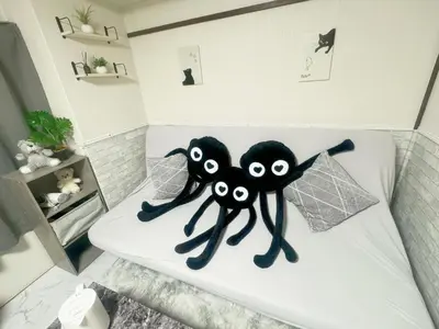 two black stuffed spiders sitting on a bed at Takadanobaba relaxing CB in Tokyo