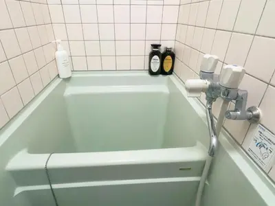 a green bath tub with a faucet in a bathroom at Takadanobaba relaxing CB in Tokyo