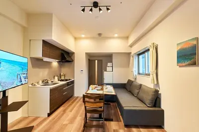 a living room and kitchen with a couch and a table at Nomadland Shinagawa Omori 1104 in Tokyo