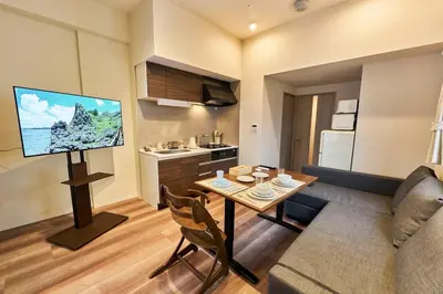 a living room with a dining room table and a television at Nomadland Shinagawa Omori 1104 in Tokyo