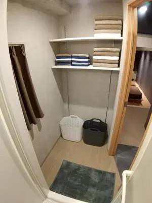 a small walk in closet with towels and a rug at Stay Chill Shinbashi in Tokyo