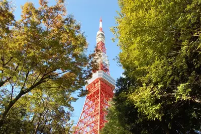 a red and white tower in the middle of trees at Stay Chill Shinbashi in Tokyo