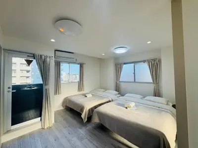 a bedroom with two beds and a large window at LOFT-Hatsudai hostel\u521d\u53f0SY0362 in Tokyo