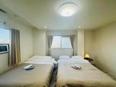 two beds in a room with a window at LOFT-Hatsudai hostel\u521d\u53f0SY0362 in Tokyo