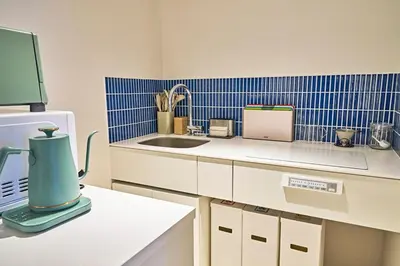 a kitchen with a counter with a sink and a refrigerator at IZURU Shiba Hamamatsucho 3F in Tokyo