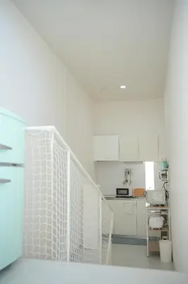 a white kitchen with white cabinets and a counter at bicyclettesumida in Tokyo