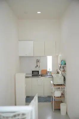 a white kitchen with white cabinets and a sink at bicyclettesumida in Tokyo