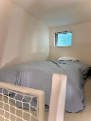 a bed in a small room with a window at bicyclettesumida in Tokyo