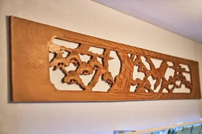 a wooden picture of trees on a wall at IZURU Shiba Hamamatsucho 2F in Tokyo
