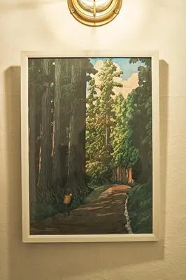 a painting of a forest hanging on a wall at IZURU Shiba Hamamatsucho 2F in Tokyo