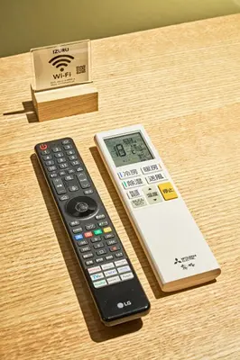 a remote control and a thermometer sitting on a table at IZURU Shiba Hamamatsucho 2F in Tokyo