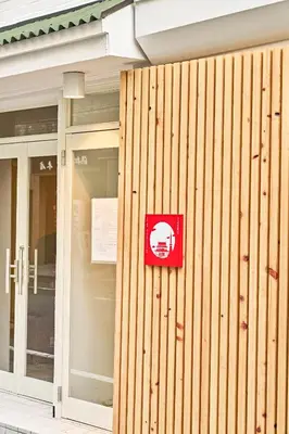 a red sign on the side of a building at IZURU Shiba Hamamatsucho 2F in Tokyo