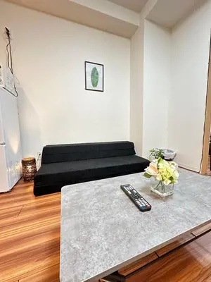 a room with a bed with a remote control on a table at SOLASIA residence \u5317\u4e0a\u91ce401 in Tokyo