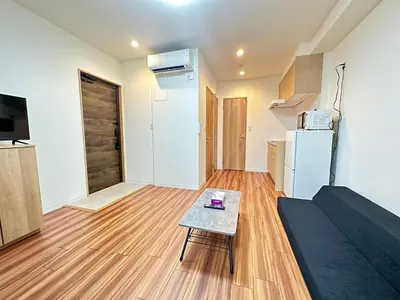 a living room with a table and a refrigerator at SOLASIA residence \u5317\u4e0a\u91ce401 in Tokyo