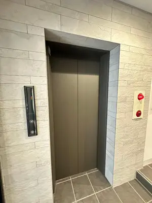 a elevator door in a building with a red light at SOLASIA residence \u5317\u4e0a\u91ce401 in Tokyo