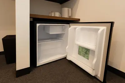 an empty refrigerator with its door open in a room at Port House Honmachi in Tokyo