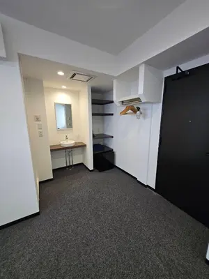 an empty room with a black door and a sink at Port House Honmachi in Tokyo