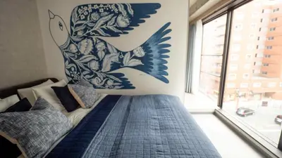a bedroom with a bed with a dolphin mural on the wall at LANG HOTEL Asakusa# 3 mins walk to Senso-ji Temple in Tokyo