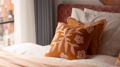 a bed with brown pillows and white sheets at LANG HOTEL Asakusa# 3 mins walk to Senso-ji Temple in Tokyo