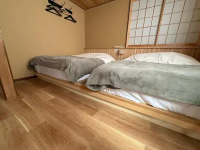 two beds in a room with wooden floors at NEW Renovated Traditional Japanese House in Sumida in Tokyo