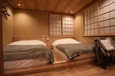 two beds in a room with two windows at NEW Renovated Traditional Japanese House in Sumida in Tokyo