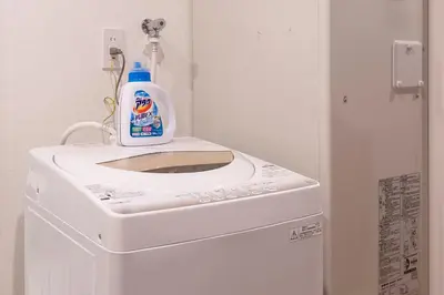 a bottle of cleaner sitting on top of a washing machine at Horizon Court Shinjuku in Tokyo