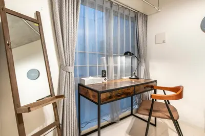 a desk with a lamp and a chair in front of a window at Horizon Court Shinjuku in Tokyo
