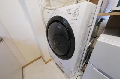 a washing machine in a kitchen next to a door at Cozy Nest Sangenjaya 1 Stop to Shibuya \u30fcWalk to Sangenjaya and Ikejiri in Tokyo