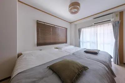 a bedroom with a large bed with a window at Cozy Nest Sangenjaya 1 Stop to Shibuya \u30fcWalk to Sangenjaya and Ikejiri in Tokyo