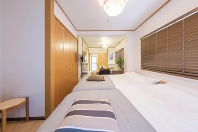 a bedroom with two beds and a large window at Cozy Nest Sangenjaya 1 Stop to Shibuya \u30fcWalk to Sangenjaya and Ikejiri in Tokyo