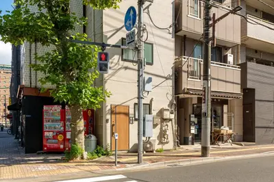 a traffic light on a city street with buildings at \u53f0\u67713\u4e01\u76ee\u6238\u5efa in Tokyo
