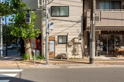 a street corner with a building and a street sign at \u53f0\u67713\u4e01\u76ee\u6238\u5efa in Tokyo