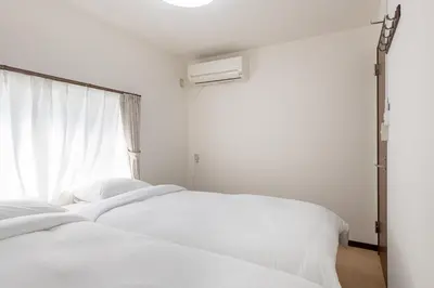 two white beds in a bedroom with a window at \u53f0\u67713\u4e01\u76ee\u6238\u5efa in Tokyo